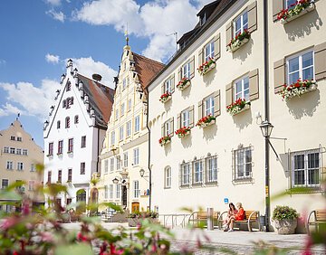 Historischer Marktplatz Zwei Freundinnen sitzen auf einer Bank vor dem Verwaltungsgebäude am historischen Marktplatz und unterhalten sich.